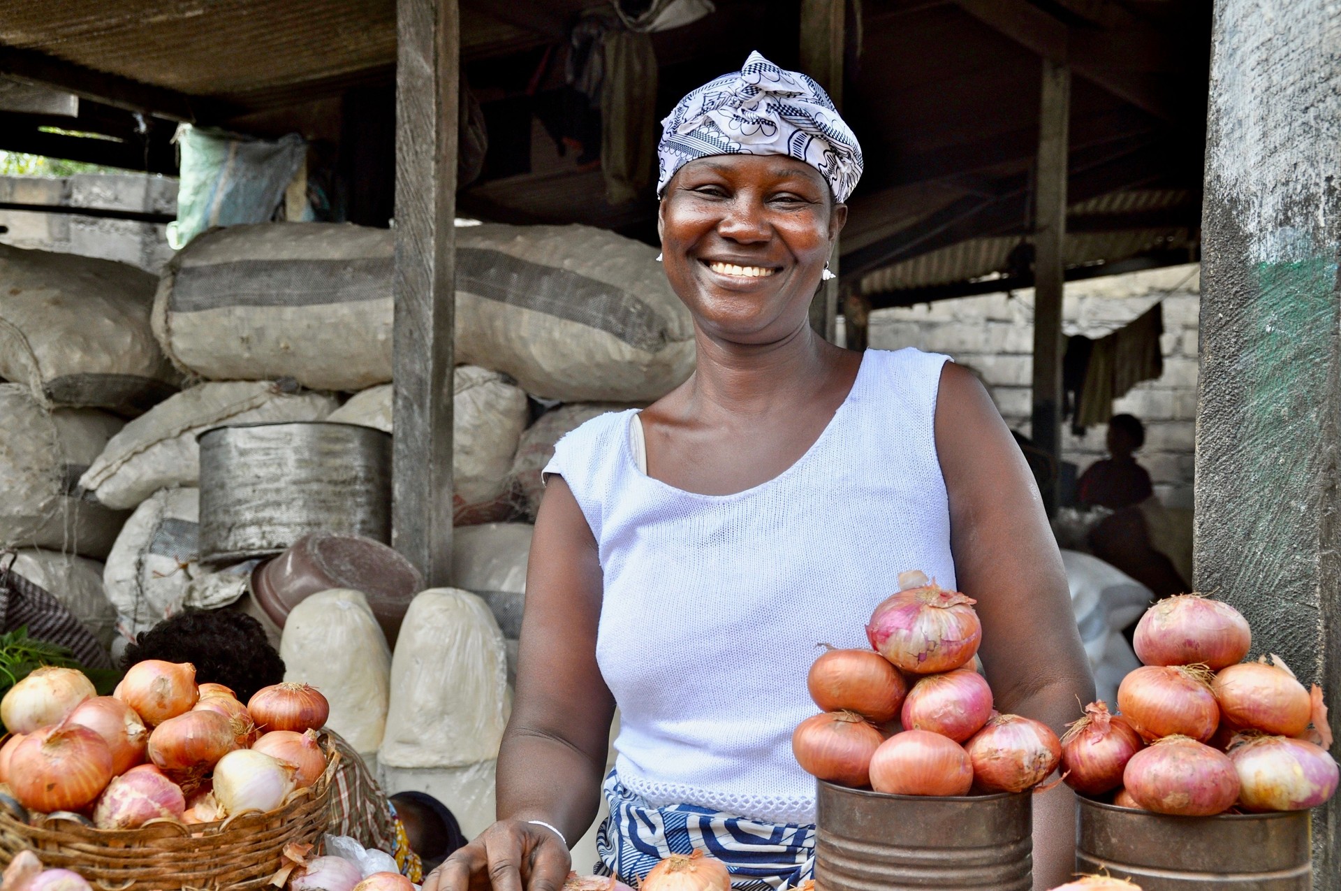 Portrait Of A Smiling Woman Selling Onions On Market